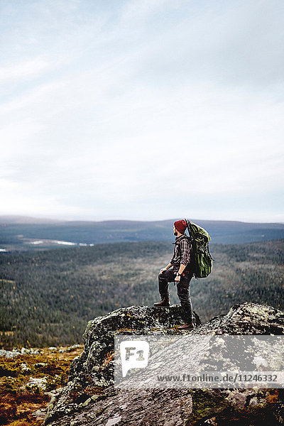 Wanderer geniesst Aussicht auf die Klippen  Keimiotunturi  Lappland  Finnland