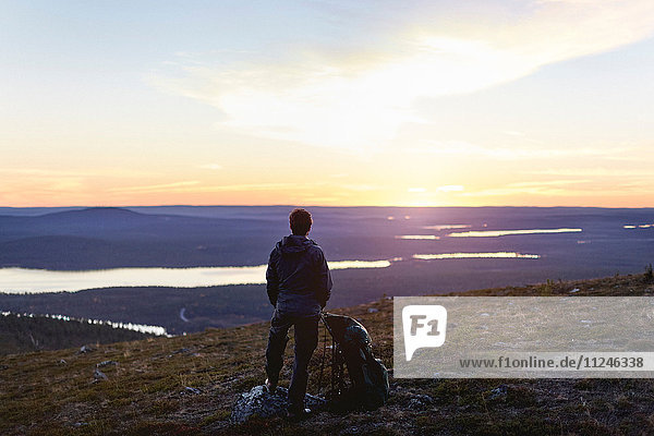 Wanderer genießt Sonnenuntergang am See  Keimiotunturi  Lappland  Finnland