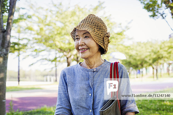 Porträt einer lächelnden älteren Frau mit Häkelmütze.
