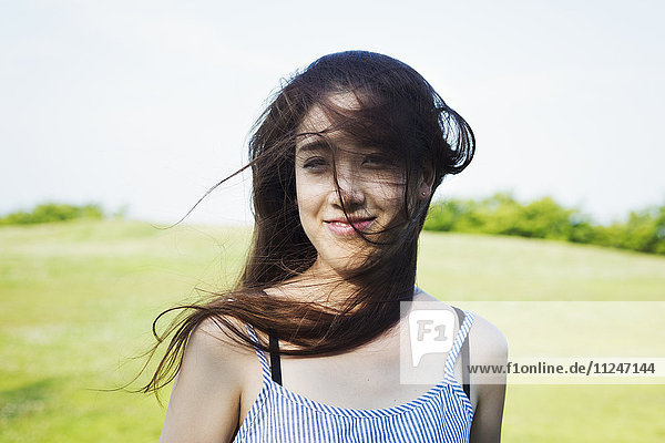 Bildnis einer lächelnden jungen Frau mit langen braunen Haaren.
