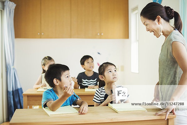 Eine Gruppe von Kindern in einem Klassenzimmer mit ihrer Lehrerin.