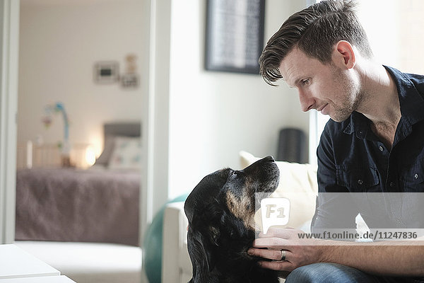 Man playing with dog in living room