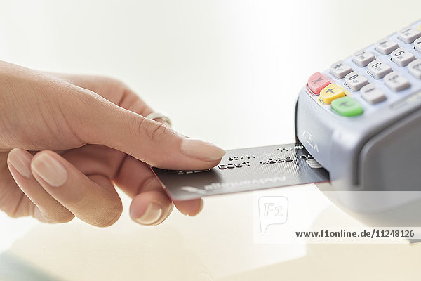 Junge Frau zahlt mit Kreditkarte