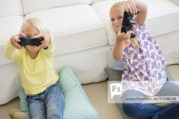 Junge (4-5) und Mädchen (6-7) spielen ein Videospiel