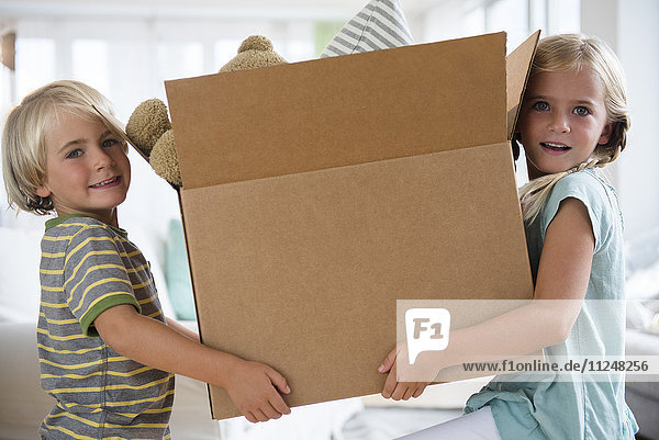 Boy (4-5) and girl (6-7) holding box