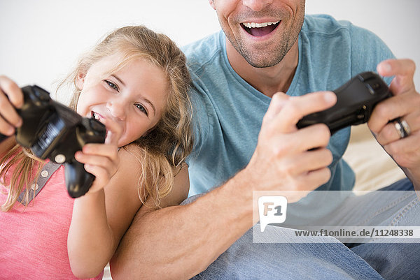 Father and daughter (7-8) playing video game
