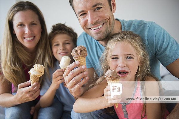 Familie mit zwei Kindern (6-7  8-9) mit Eistüten in der Hand