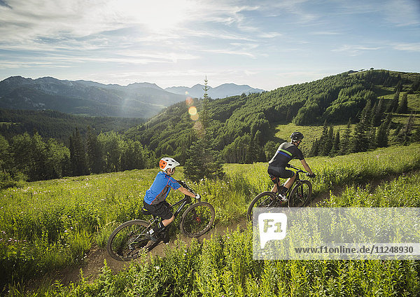 Vater und Sohn (10-11) beim Radfahren in den Bergen