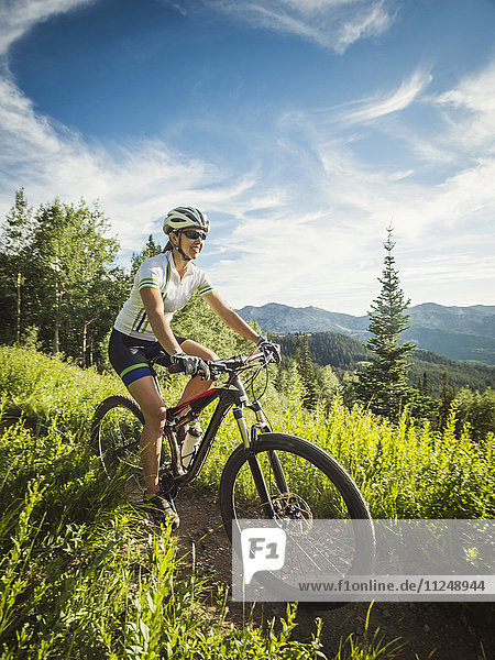 Frau bei Fahrradtour in Berglandschaft