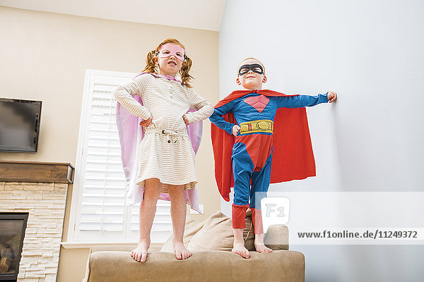 Children (2-3 4-5) playing superhero on sofa