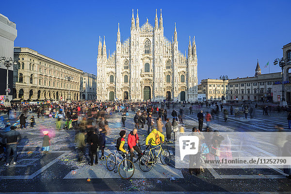 Radfahrer in der warmen Frühlingssonne vor der Fassade des gotischen Doms  Mailand  Lombardei  Italien  Europa