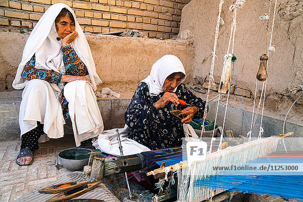 Alte Frauen beim Weben von Textilien  Varzaneh  Iran  Naher Osten