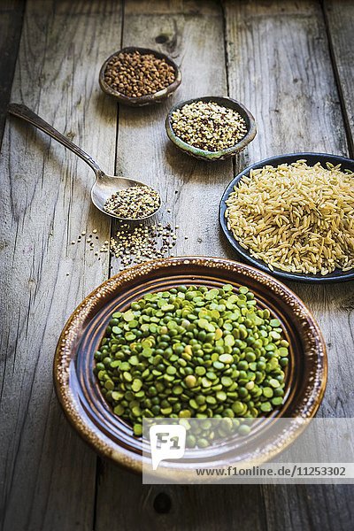 Spalterbsen  Brauner Reis  Quinoa und Buchweizen auf Holzuntergrund