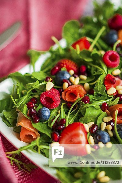 Gesunder Salat mit Rucola  Spinat  geräuchertem Lachs und Beeren