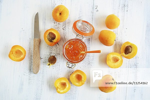 Aprikosenmarmelade in Vorratsglas und Aprikosen