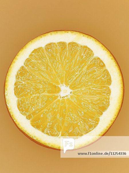 Aufgeschnittene Orange vor orangem Hintergrund  Close-Up