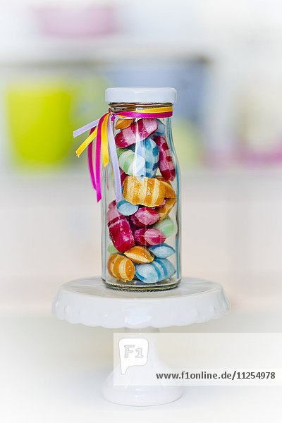 Bunte Bonbons in einer kleinen Glasflasche