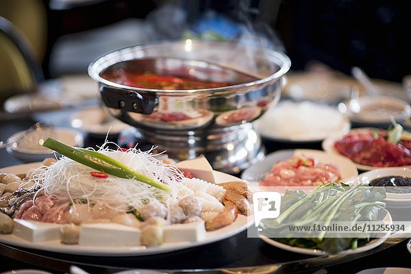 Gedeckter Tisch mit Zutaten für chinesisches Fondue (Asien)