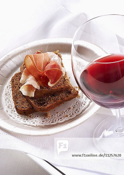 Kastanienbrot mit Rohschinken und Glas Rotwein