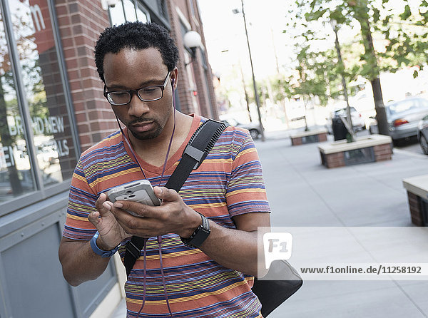 Mid adult man with phone in street