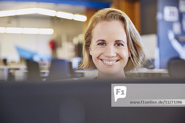 Porträt einer lächelnden Geschäftsfrau bei der Arbeit am Computer