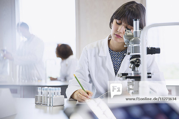 Female college student conducting scientific experiment in science laboratory classroom