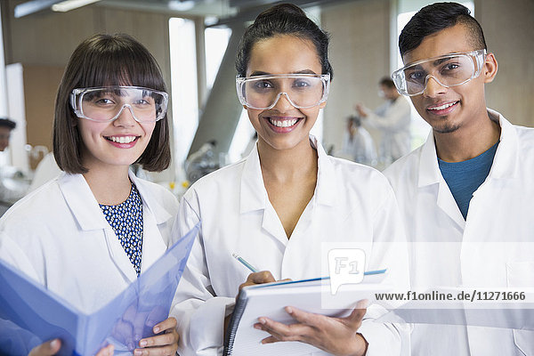 Portrait smiling college students in science lab coats