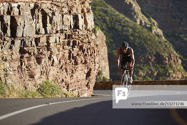 Male triathlete cycling uphill