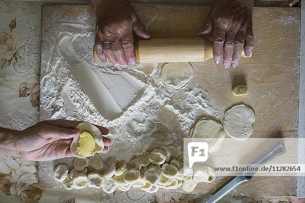 Hands of Caucasian woman rolling pastry dough