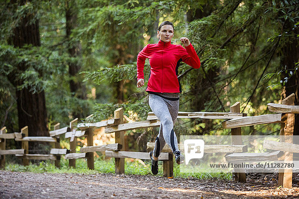 Frau läuft auf Waldweg