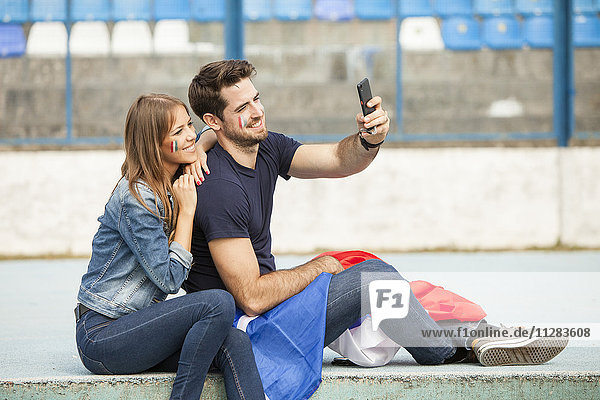 Young couple with French flag taking a selfie