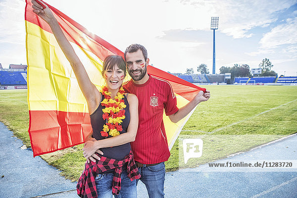 Young couple with face paint and Spanish flag
