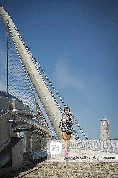 Kaukasische Frau läuft auf Brücke