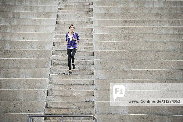 Kaukasische Frau läuft auf der Stadiontreppe