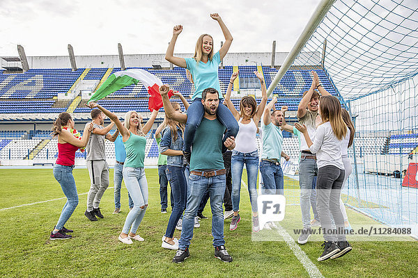 Eine Gruppe von Fußballfans feiert mit der italienischen Flagge