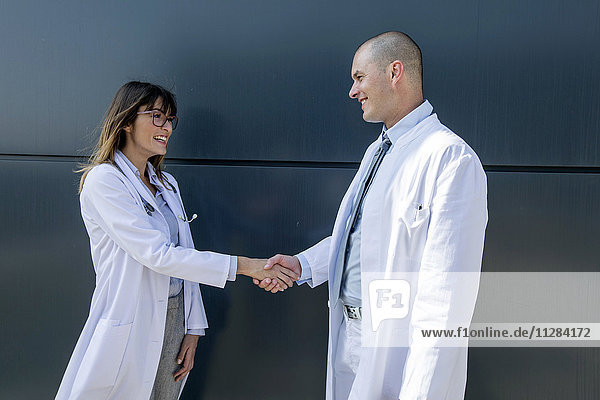 Female doctor and male doctor shaking hands