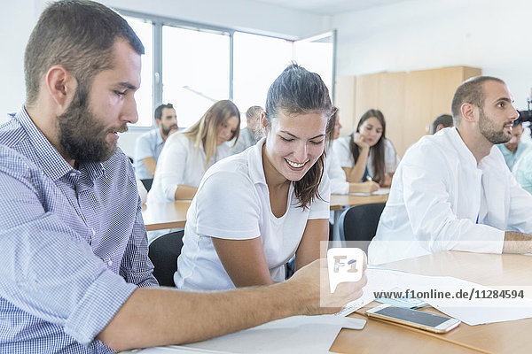 Students in training class looking at smartphone