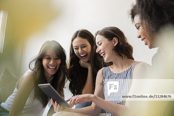 Smiling women using digital tablet