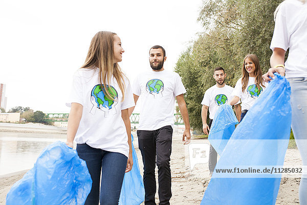 Freiwillige Teenager bei der Müllsäuberung am Flussufer