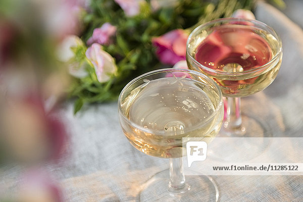 Gläser mit Champagner in der Nähe von Blumen
