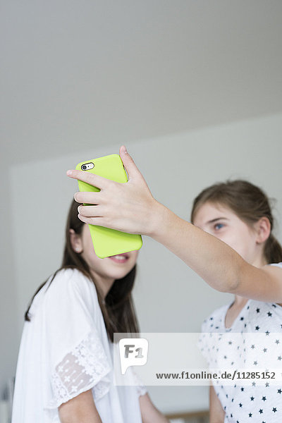 Zwei Mädchen im Teenageralter machen ein Selfie mit Smartphone