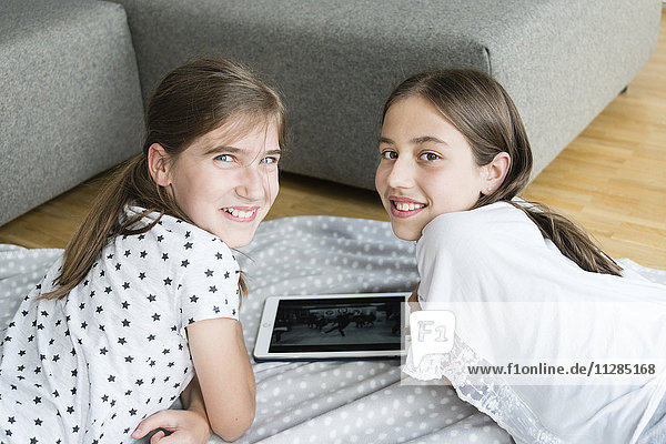 Teenage girls using digital tablet at home