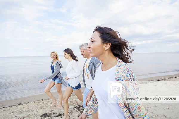 Group of friends take a walk along the beach