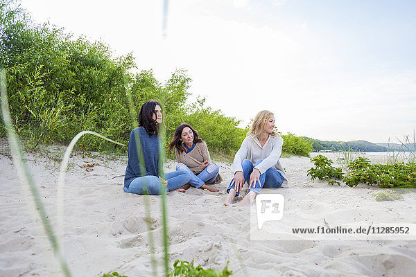 Group of women sitting on sandy beach
