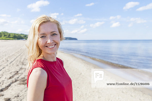 Porträt einer Frau mit blondem Haar am Strand