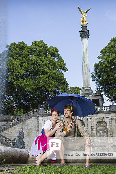 Junges Paar sitzt vor dem Friedensengel-Denkmal