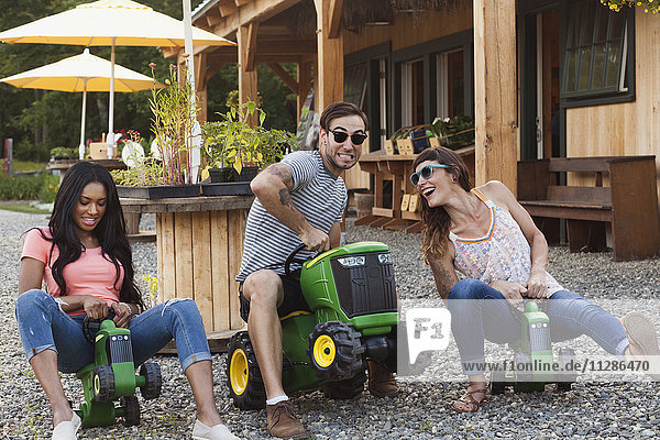 Friends playing on toy tractors