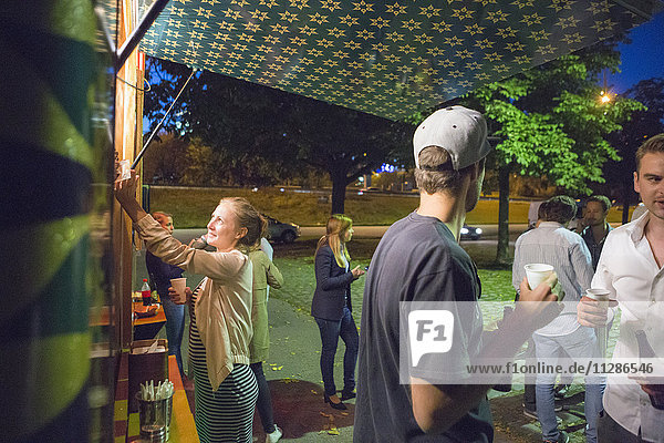 Group of customers at food truck at night
