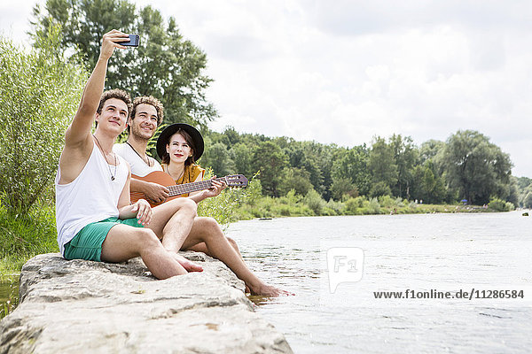 Group of friends relaxing on the riverbank