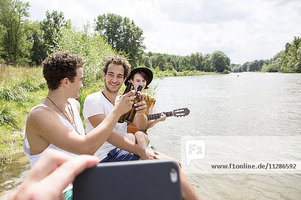Group of friends relaxing on the riverbank